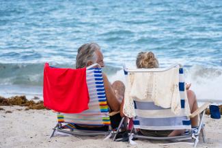 Retired couple laying on the beach enjoying an experience together