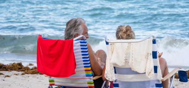 Retired couple laying on the beach enjoying an experience together